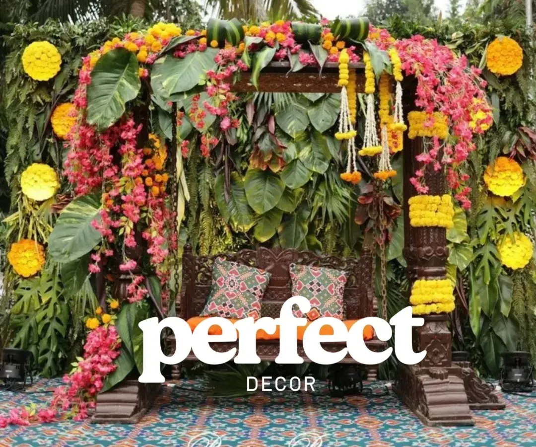 For pre-wedding functions like Mehendi or Haldi, I love creating vibrant, joyful spaces. This traditional wooden jhoola, heavily decorated with marigolds and bougainvillea against a lush green wall, is a perfect photo spot.