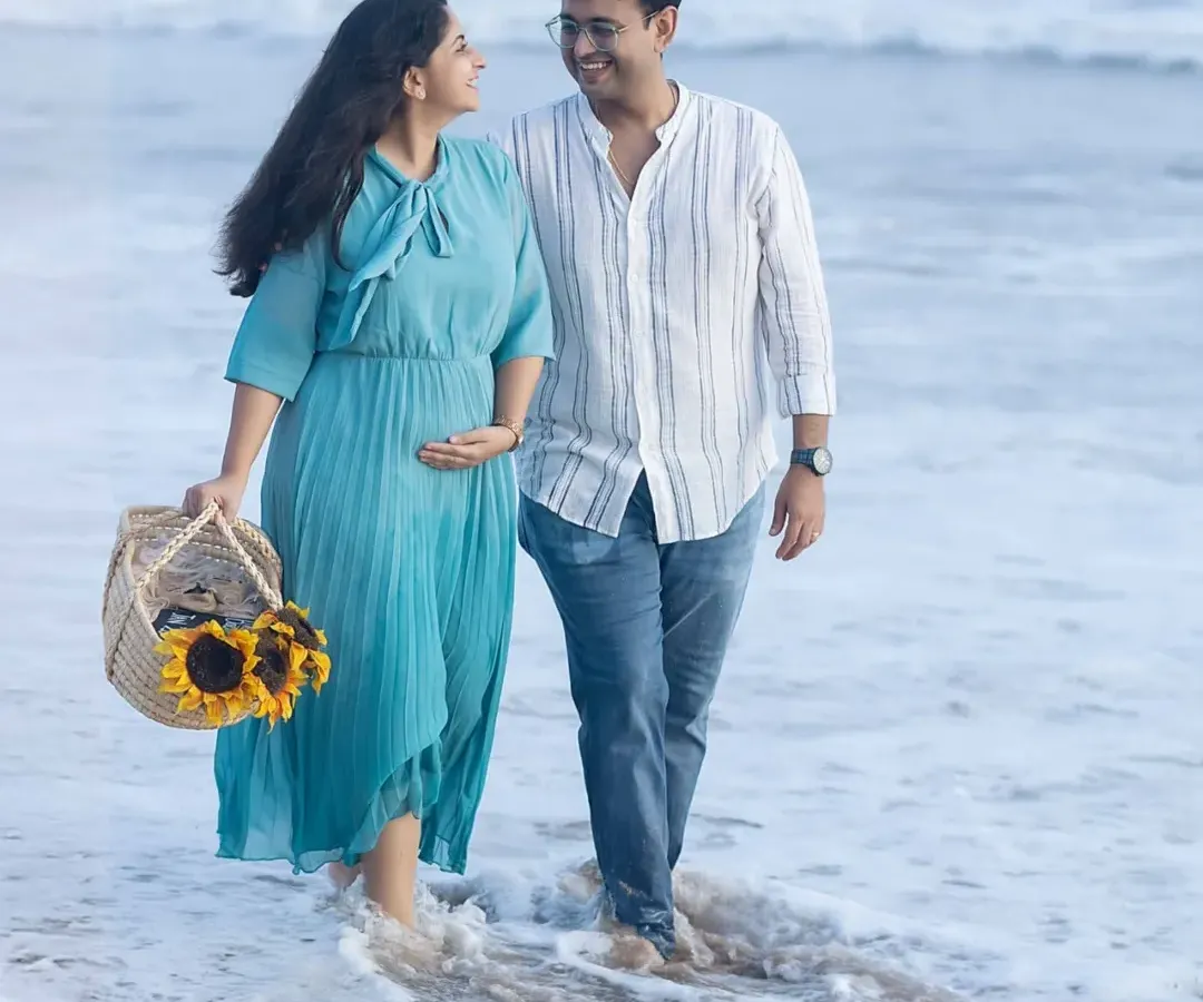 A gentle stroll along the shore during the magical golden hour. This beach maternity session captures the relaxed and joyful connection between the couple, with a basket of sunflowers adding a perfect pop of color.
