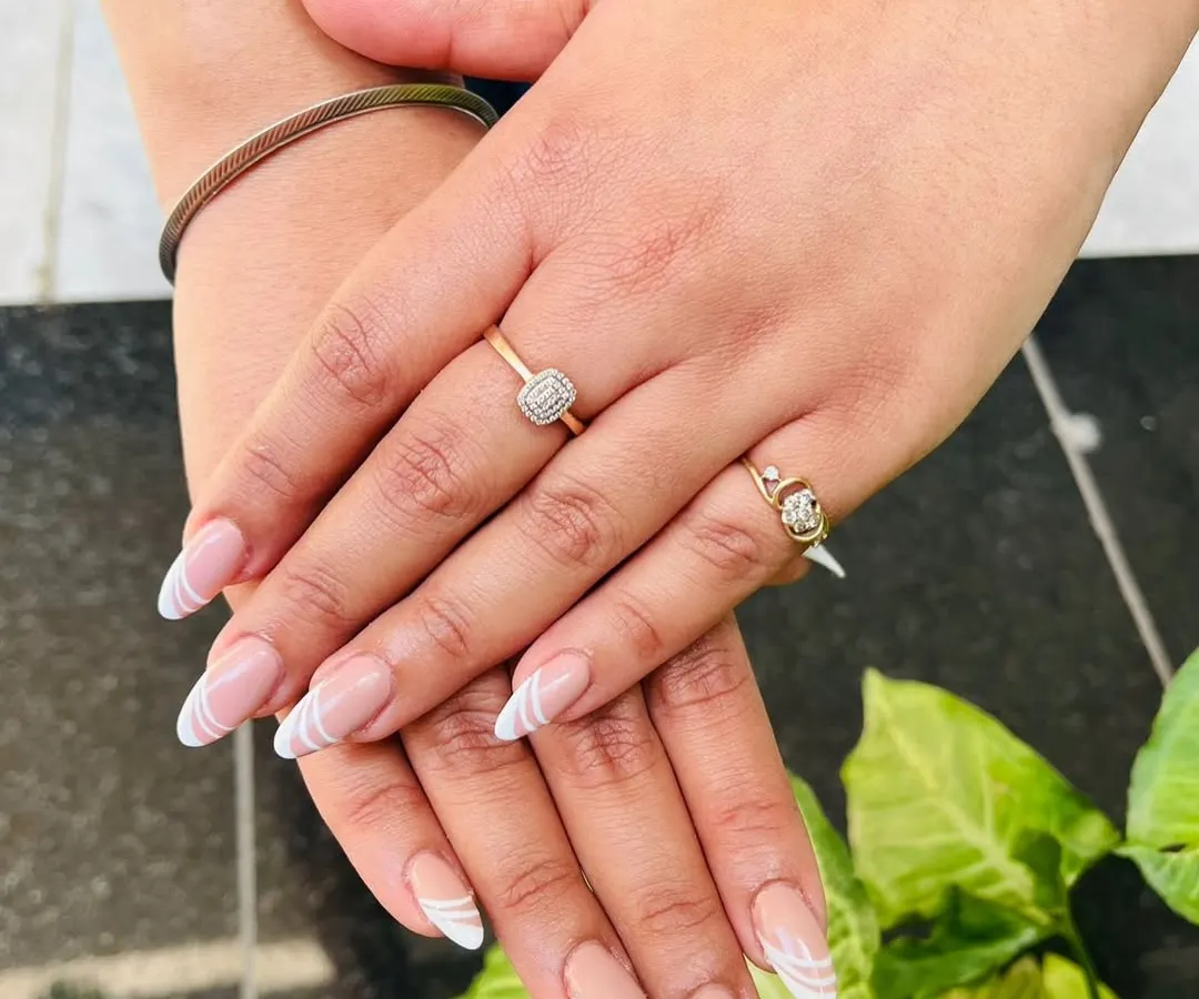 Here is a modern twist on the classic French tip, with clean white swirls on a natural nude base. This design is perfect for an everyday look that is still chic and eye-catching.