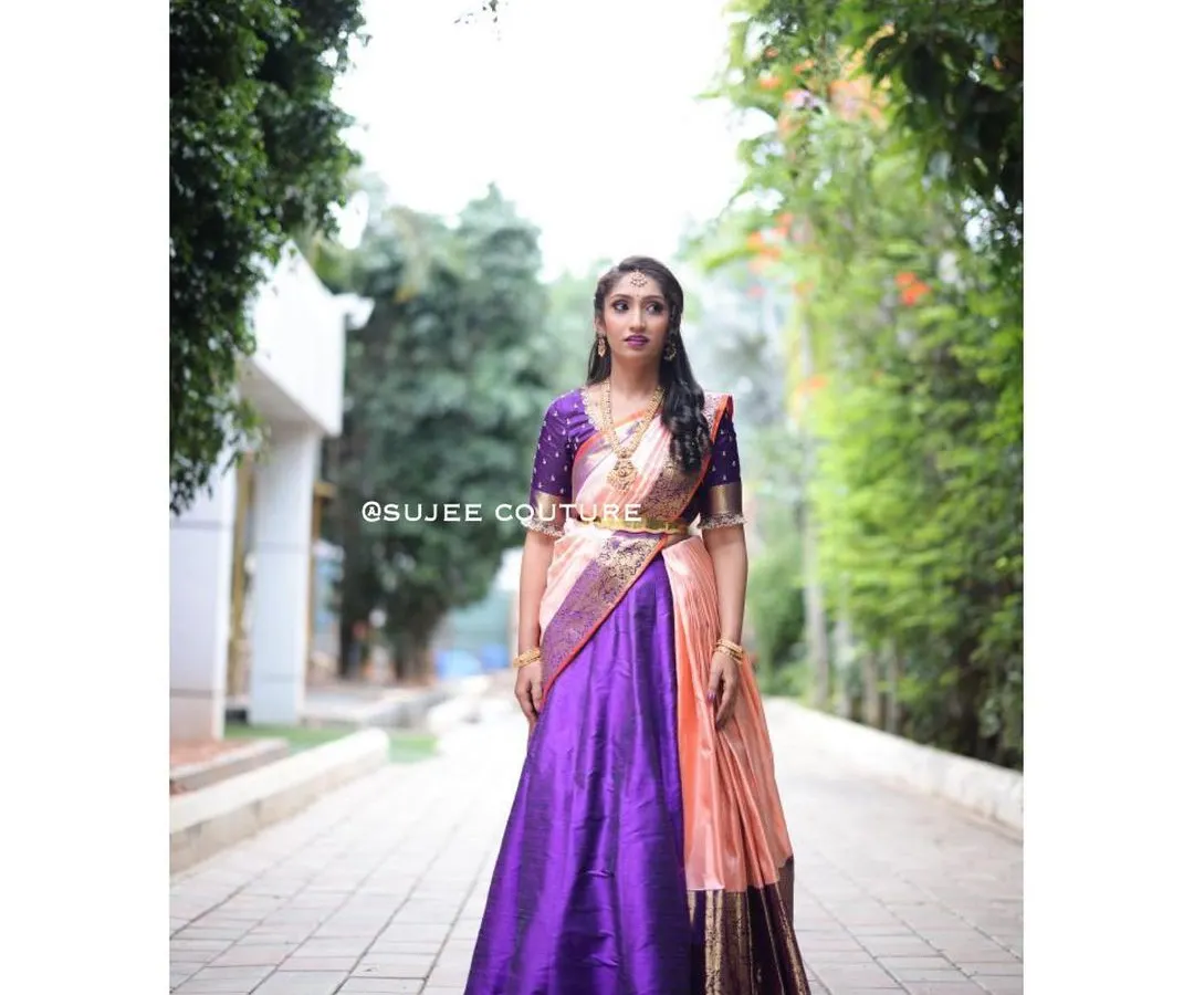 This is a complete South Indian half saree, or langa voni, that I designed. The rich purple silk skirt contrasts beautifully with the peach and gold dupatta, creating a stunning outfit perfect for a wedding or pre-wedding celebration.
