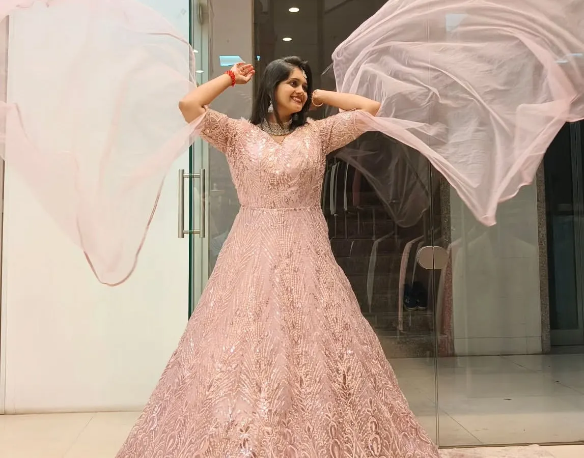 Feel like you're floating in a dream with this ethereal pink gown. The delicate embroidery and flowing fabric are perfect for a reception or engagement, ensuring you sparkle with every step and twirl.