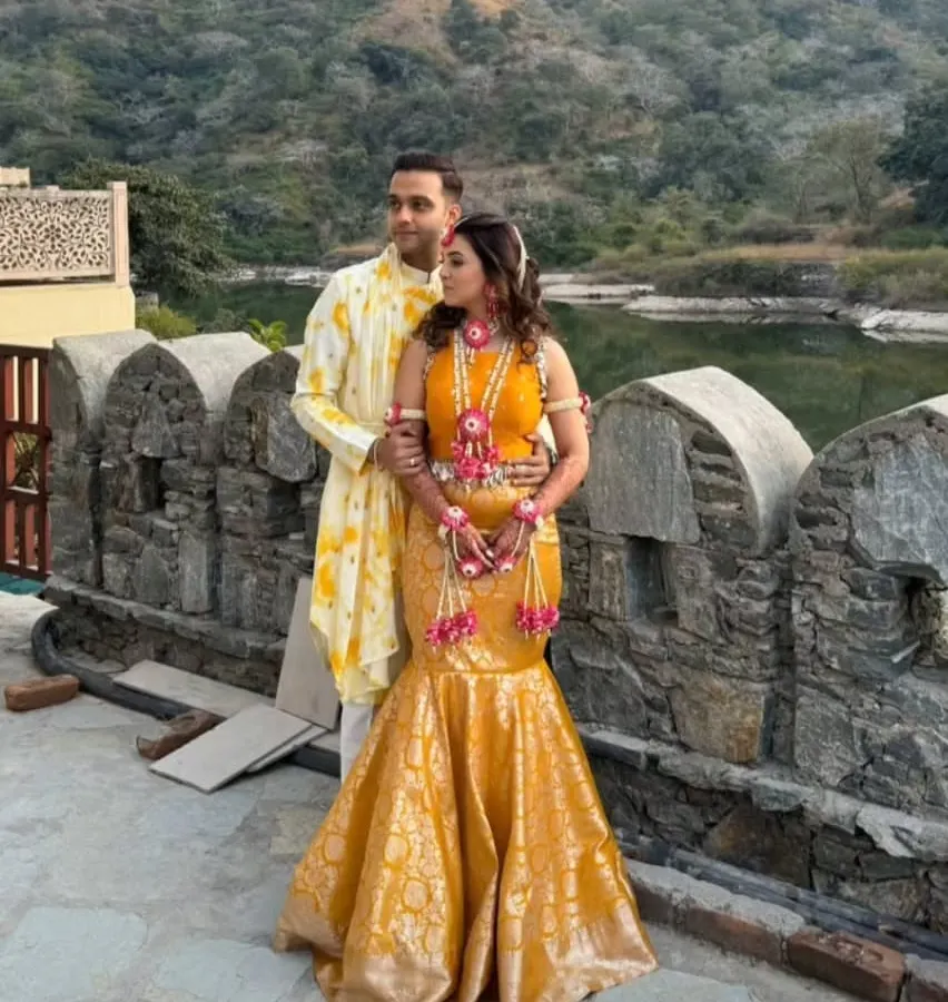 For this beautiful couple's Haldi ceremony, I designed a coordinated set that felt festive and personal. The groom wears a custom-printed yellow kurta, perfectly complementing the bride's bespoke mermaid skirt. My goal is to create looks where couples coordinate without being overly matched.