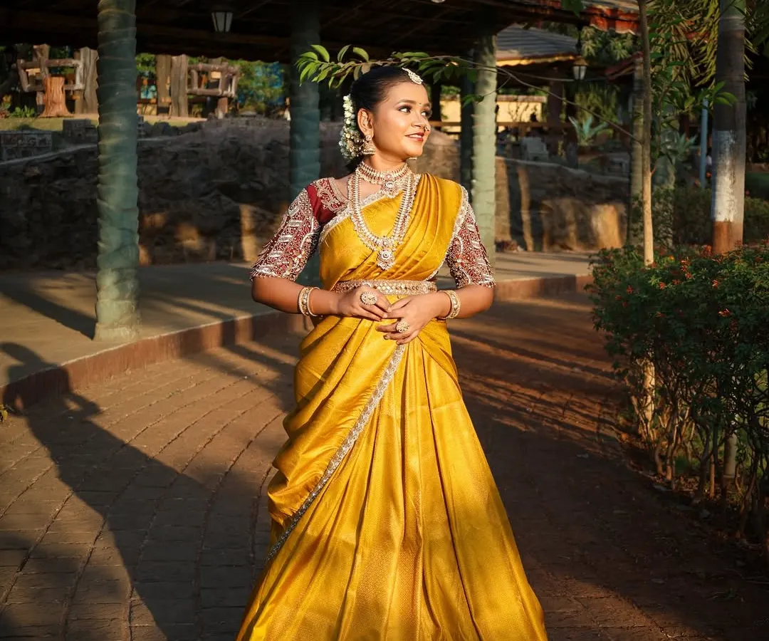 For a beautiful traditional look, I offer authentic South Indian half-sarees, also known as Langa Voni. This vibrant yellow silk piece is perfect for cultural functions or a unique pre-wedding photoshoot, and includes all the traditional temple jewellery you see here.