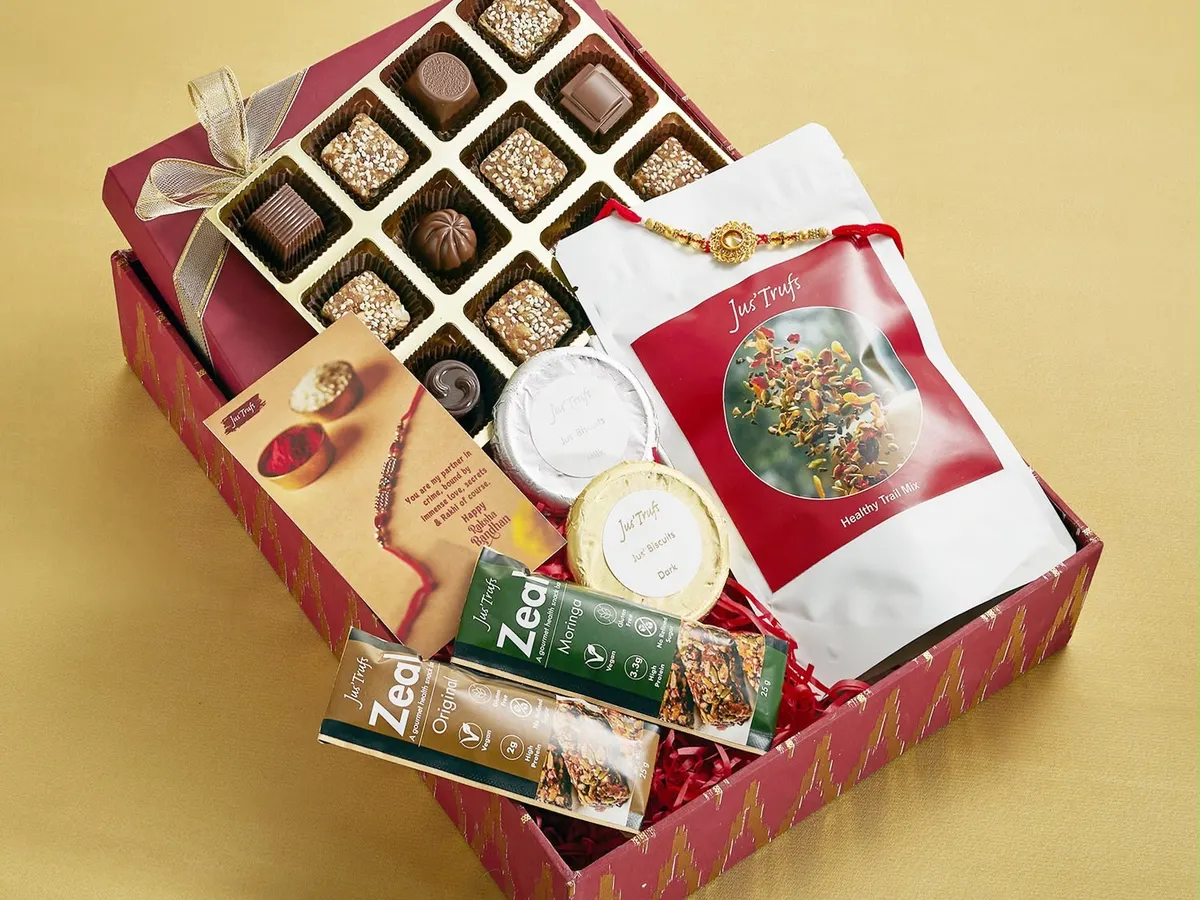 Our red festive hamper brings assorted chocolates, Hot Chocolate Mix, Zeal bars and gift components together with a Rakhi card.