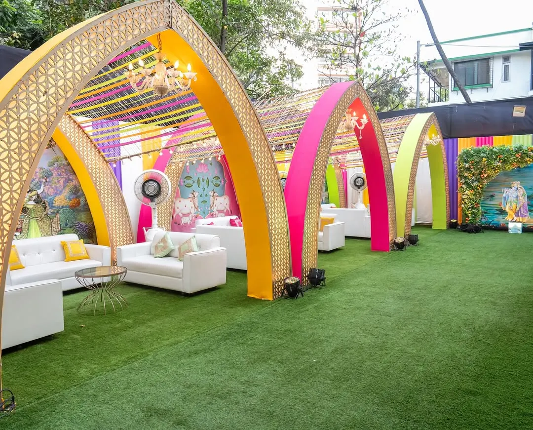 This outdoor lounge area was designed for a vibrant Garba night. We used a series of colorful arches with intricate gold lattice work and ribbon canopies to create semi-private seating zones, combining modern comfort with a festive, traditional atmosphere.