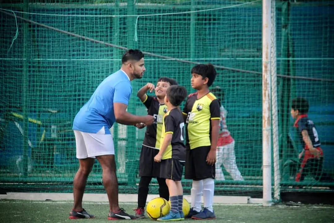 A moment of encouragement between a coach and our young footballers. We focus on guiding our players towards success, celebrating small wins and building their self-esteem on and off the pitch.