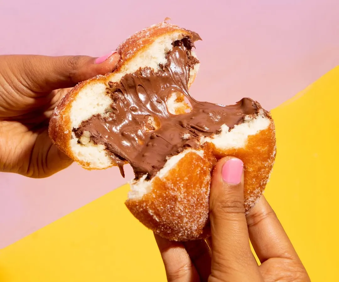 You have to see it to believe it. This is my Nutella stuffed bomboloni, an Italian-style donut that's airy, fluffy, and absolutely packed with chocolate-hazelnut goodness. All my donuts are 100% eggless and made fresh every single day.