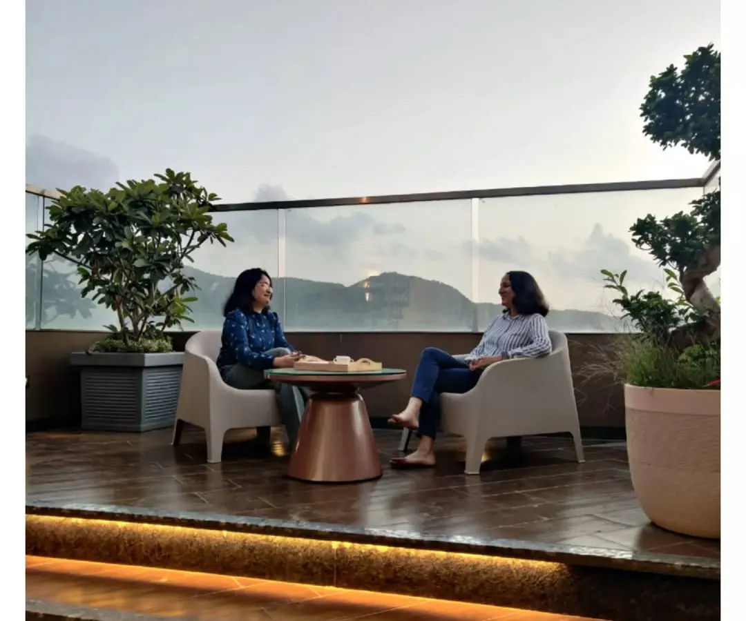 Here you can see the second terrace of the same penthouse, designed for enjoying the scenic view. We used a simple wooden deck and a clear glass railing to keep the focus on the landscape. This space shows how we create functional outdoor seating areas perfect for quiet moments or conversations.