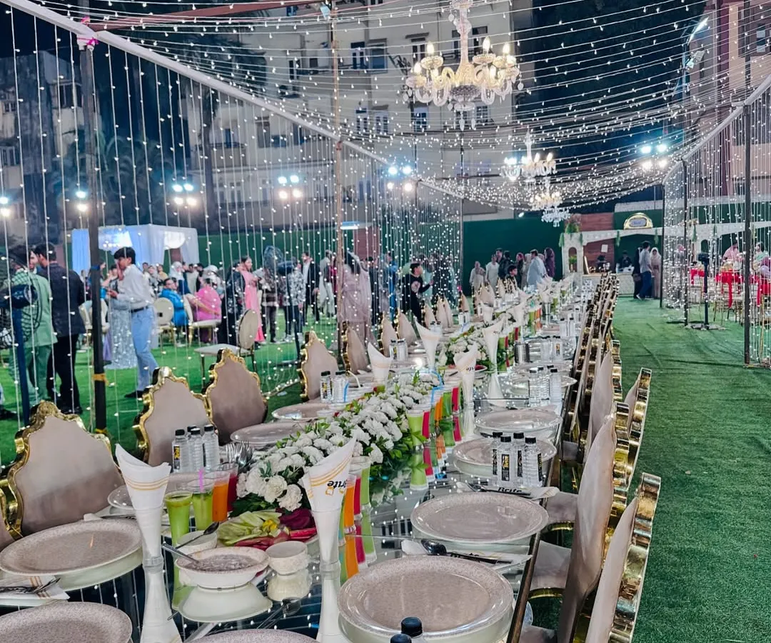 I believe the dining experience is paramount. Here is an example of an elegant, long-table sit-down arrangement, complete with floral centerpieces and premium tableware, designed for a grand wedding feast.