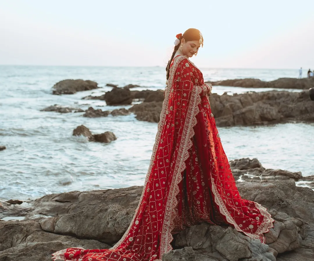 We believe every bride deserves a portrait that feels like a piece of art. Here, we used the dramatic backdrop of the sea and the flowing red lehenga to create a timeless, powerful image of Alifa on her big day.
