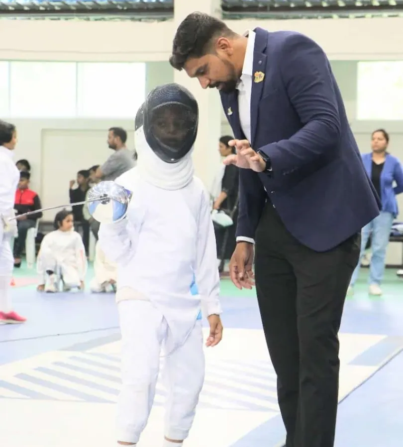 Mentorship is at the heart of what we do. Here, I am providing one on one guidance to a young fencer, helping her refine her stance and grip. We believe every champion starts with a coach who believes in them.