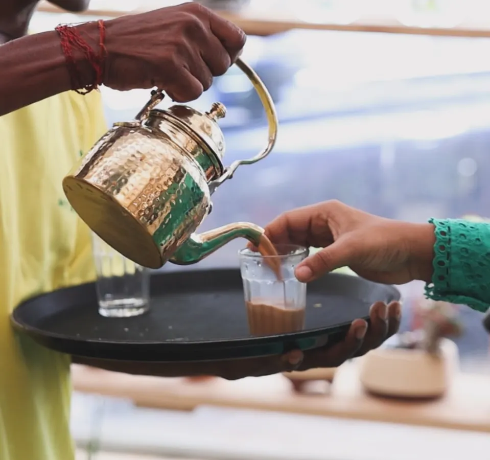 Nothing beats the comfort of a perfectly brewed cup of chai. Here you can see us pouring our special Kolkata-style tea from a traditional brass kettle. We serve it hot and fresh, making it a highlight for any get-together or party.