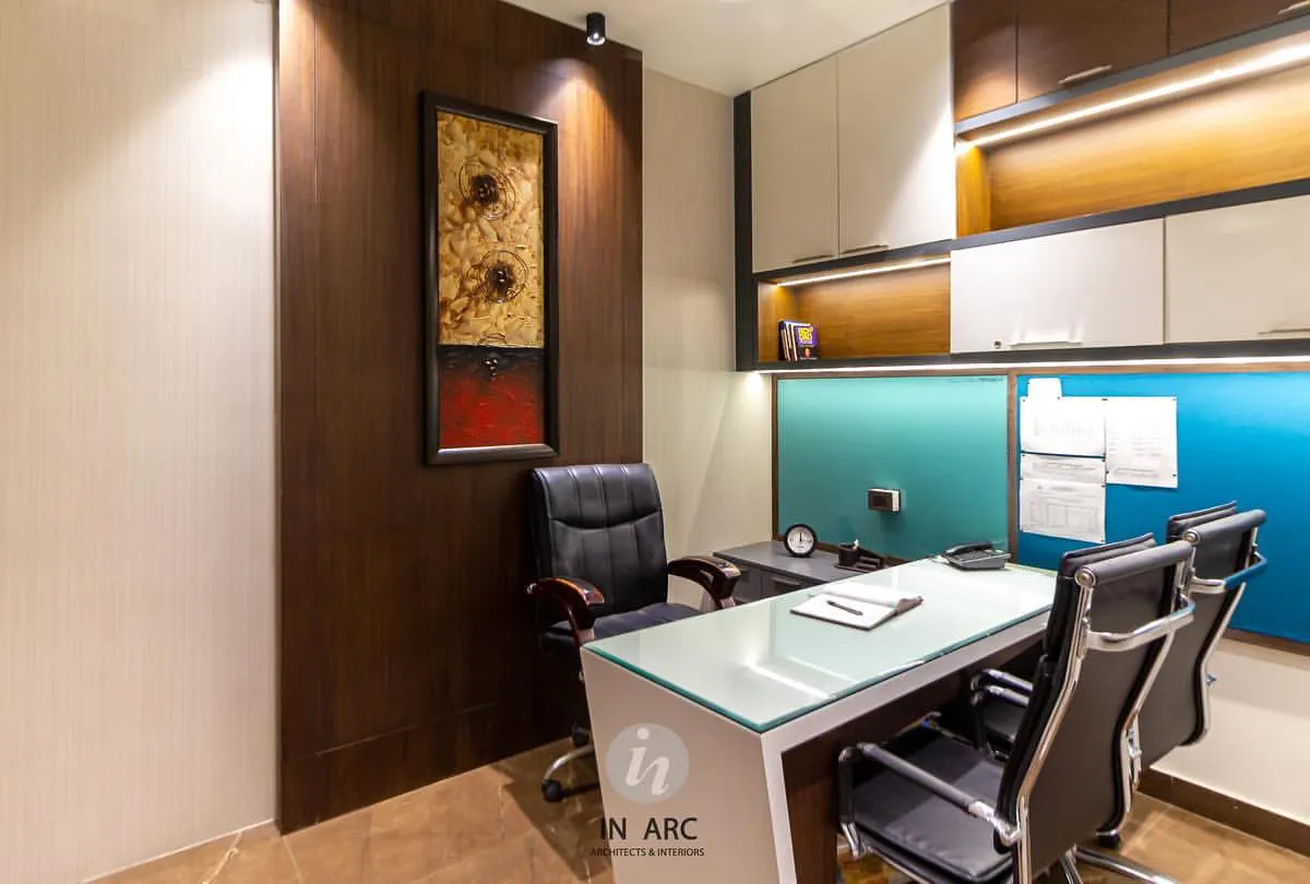 This is a director's cabin we designed for an educational institute in Nandigram. The space combines warm wood veneers with cool tones and strategic accent lighting to create an environment that is professional, focused, and sophisticated. Every element, from the glass-top desk to the built-in shelving, is chosen for function and style.