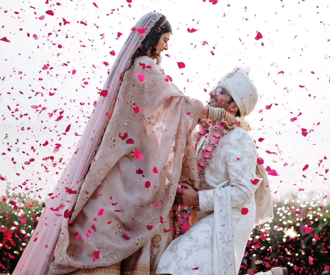 The beautiful varmala ceremony, where the groom kneels amidst a shower of petals. It's these emotional, unscripted moments that we love to capture.