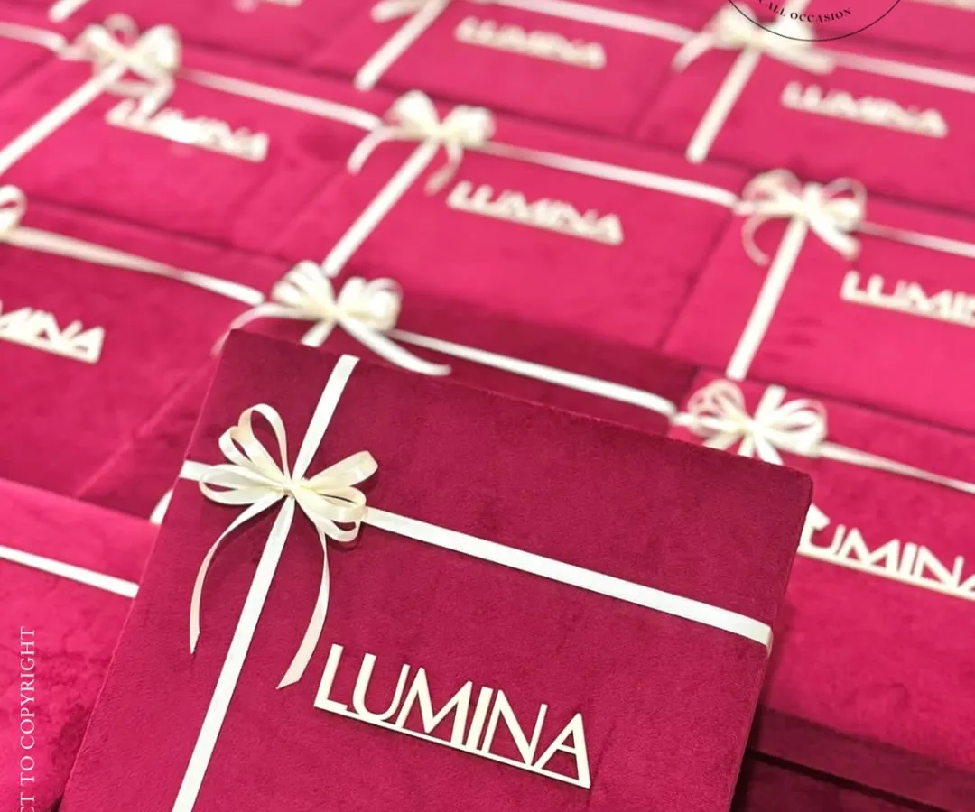 For corporate events that demand sophistication, I create custom-branded packaging that speaks your brand's language. These plush velvet boxes, personalized for the 'LUMINA' launch, show how I can translate a theme into a tangible, luxurious experience for your guests.