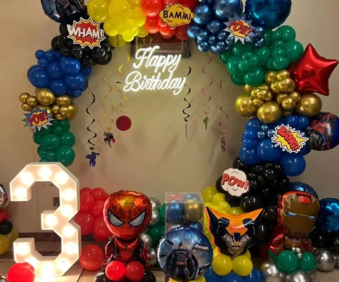 We assembled the entire Avengers team for this superhero-themed birthday party. The setup features a circular balloon arch in signature hero colors, character balloon sculptures of Spider-Man and Iron Man, a light-up marquee number '3', and a custom 'Happy Birthday' neon sign.