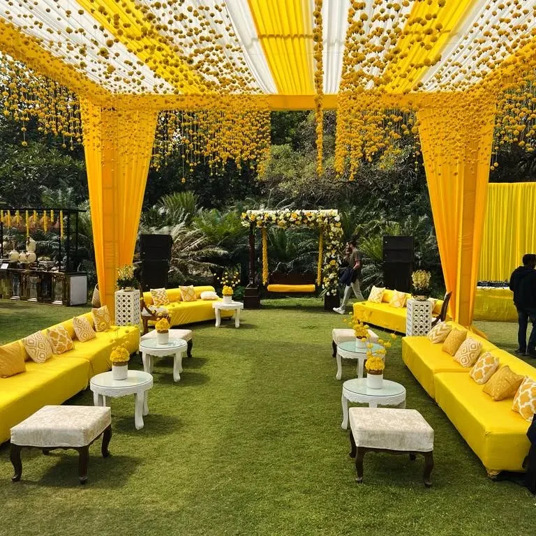 This is the classic Haldi vibe I love to create. The entire space is drenched in sunshine yellow, with marigold curtains, comfortable sofas for guests, and a decorated jhoola, making it perfect for photos and fun.