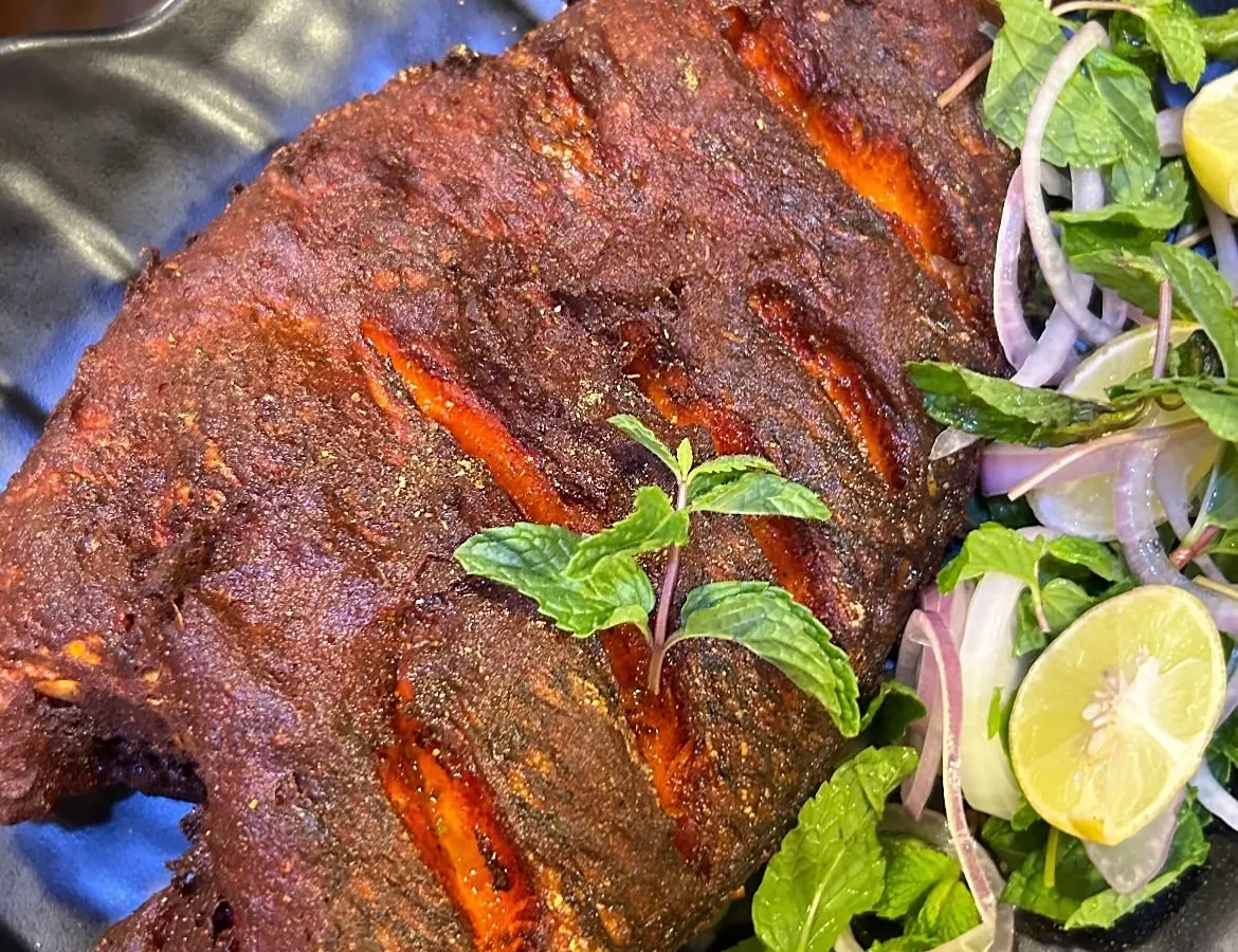 This is our legendary Tandoori Fried Fish, a dish we are truly famous for. We use fresh Tilapia, marinate it in our secret blend of tandoori spices, and fry it to crispy perfection. It's a must-try when you visit us.
