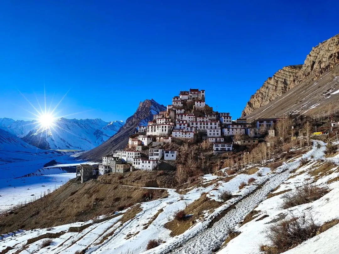 The iconic Kee Monastery in Spiti Valley, perched under a brilliant blue sky. This shot captures the scale and spiritual serenity of the Himalayas, a perspective only possible with high-altitude landscape photography.