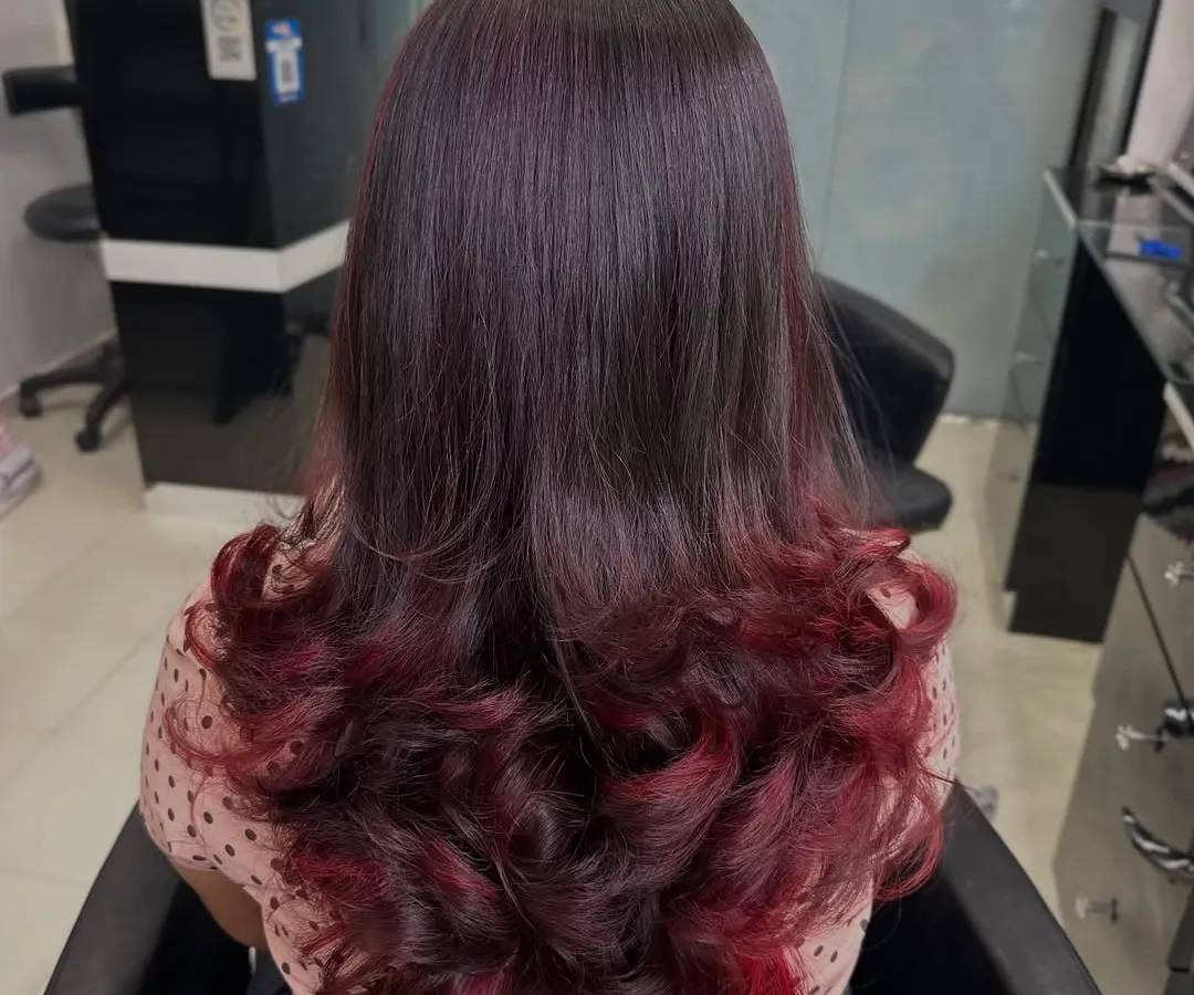 For clients who want a bold yet elegant change, I love creating looks like this plum red ombre. The color melts from a natural dark base into vibrant red ends, styled with soft curls to show off the color gradient. This is a great way to express your personality.