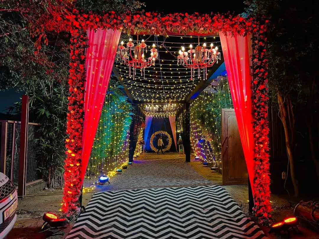 I make sure your guests are impressed from the moment they arrive. This grand entrance tunnel was created with a red floral arch, chandeliers, and fairy lights for a truly magical welcome.