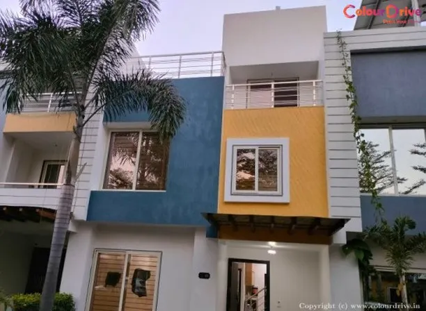 This modern villa's exterior was transformed with a durable, weather-resistant paint combination. We used a sophisticated palette of blue, yellow, and white to enhance the building's architectural features and provide long-lasting curb appeal.