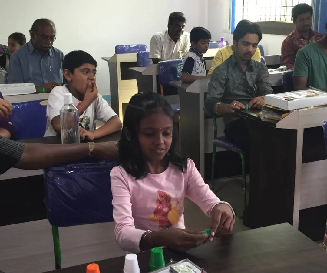 Here you can see the fun in action. Students, both young and old, are getting hands-on with their personal magic kits, practicing the cups and balls trick. This is what my workshops are all about: interactive learning for everyone.