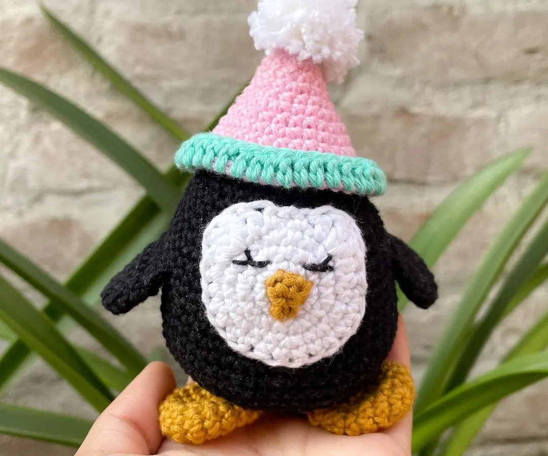Meet Zippy the penguin. This little amigurumi character is made with soft cotton yarn and has a sweet, sleepy expression. I love how the little pom-pom party hat gives him such a fun personality.