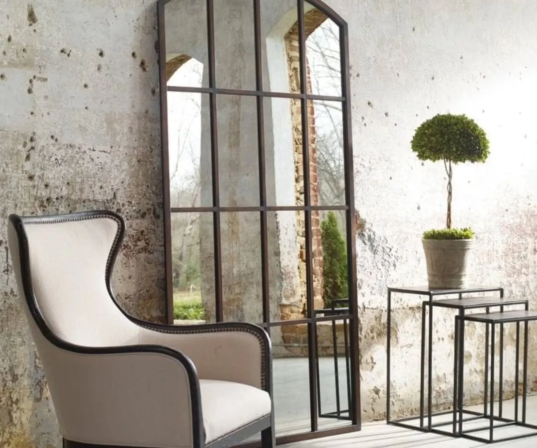 This grand, arched window-pane mirror serves as a stunning architectural feature in this living space. We crafted it to create an illusion of space and light, using a rustic metal frame for a classic, industrial-loft feel. We build large-scale statement mirrors to your exact dimensions.
