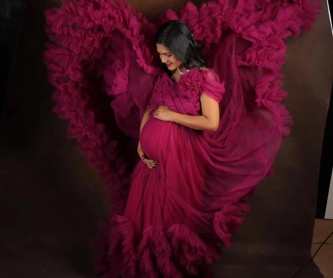 Feel like a goddess in this magenta flying gown, designed to make your maternity photoshoot absolutely breathtaking. The way the ruffled trail catches the air creates stunning, dynamic images that you will cherish forever.