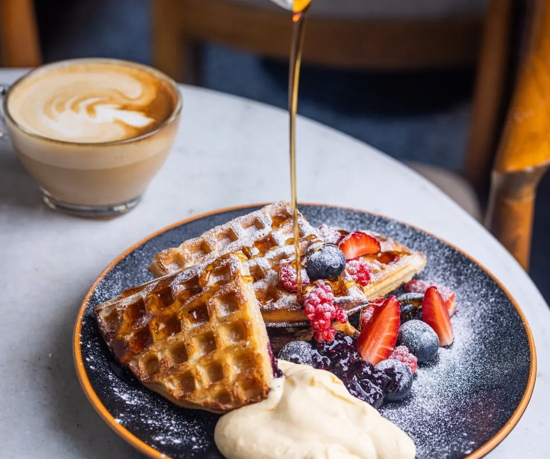 I love watching the syrup cascade over a stack of warm waffles. Mine are made to be crisp on the outside with a soft, airy heart, topped with a medley of fresh berries and a dollop of whipped cream. It’s pure, simple joy on a plate.