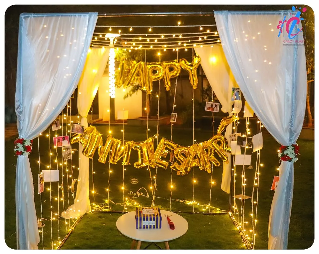 We transform any space into a private romantic getaway with our anniversary cabana decor. This setup includes a canopy of soft white drapes, hundreds of warm fairy lights, and personalized photo displays to celebrate your journey together.