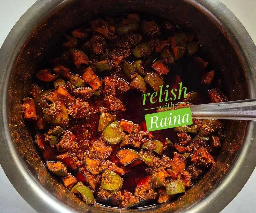 Here you can see my classic Spicy Khatti Kairi Pickle being prepared. I use Ladua kairi, a type of raw mango known for its sour taste and fleshy pulp, and mix it with my family's secret masala blend. This picture shows the pickle just after mixing, before it's left to mature and let the flavours deepen.