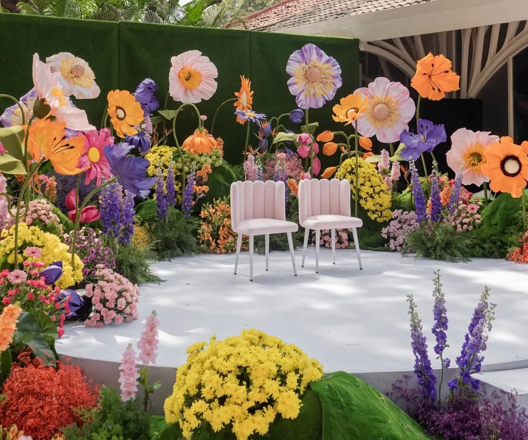 I love bringing vibrant, whimsical visions to life. This main stage, bursting with oversized, colorful paper flowers and lush arrangements, created a playful yet stunning focal point for a truly unique wedding ceremony.