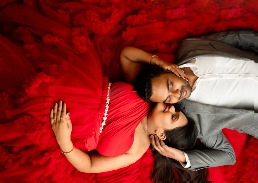 Couple portraits are about capturing your connection before the new arrival. This top-down shot in a vibrant red gown creates an intimate and visually striking memory for you and your partner.