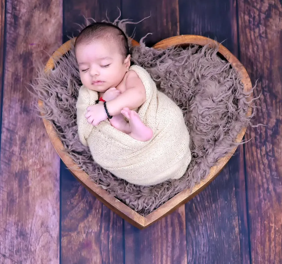 The pure innocence of a newborn is something we cherish. This simple, heartfelt pose in a heart-shaped basket is a timeless way to remember how small they once were.