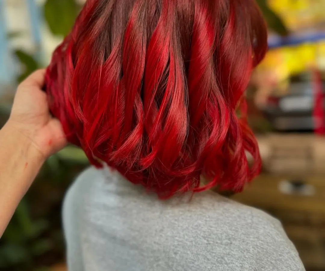 This fiery red is not for the faint of heart. We went for a full global color and a sharp bob cut for a complete makeover that is pure confidence. This look required bleach to get that vibrant, true red.