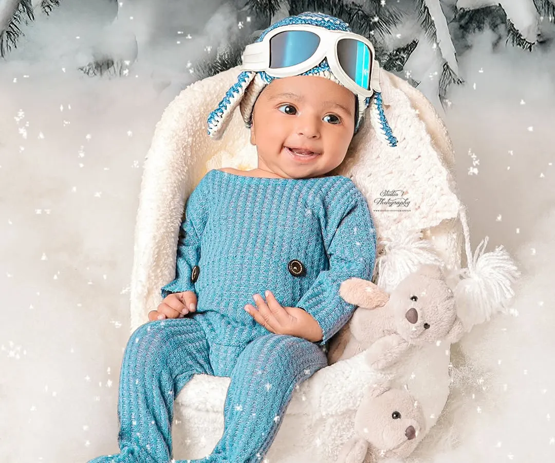 Look at that smile. This sitter session captures the pure joy of a baby who has just discovered the fun of sitting up. I created this winter wonderland theme right in my Rohtak studio to give this little explorer a magical, snowy backdrop for his portrait.