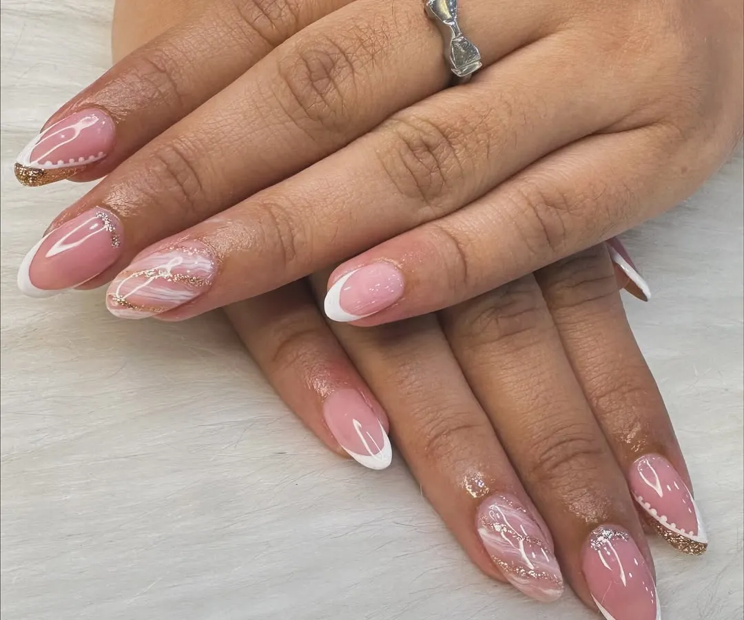 A modern twist on a timeless classic. This look combines a clean French manicure with delicate marble art and a hint of gold glitter for an elegant and sophisticated finish.