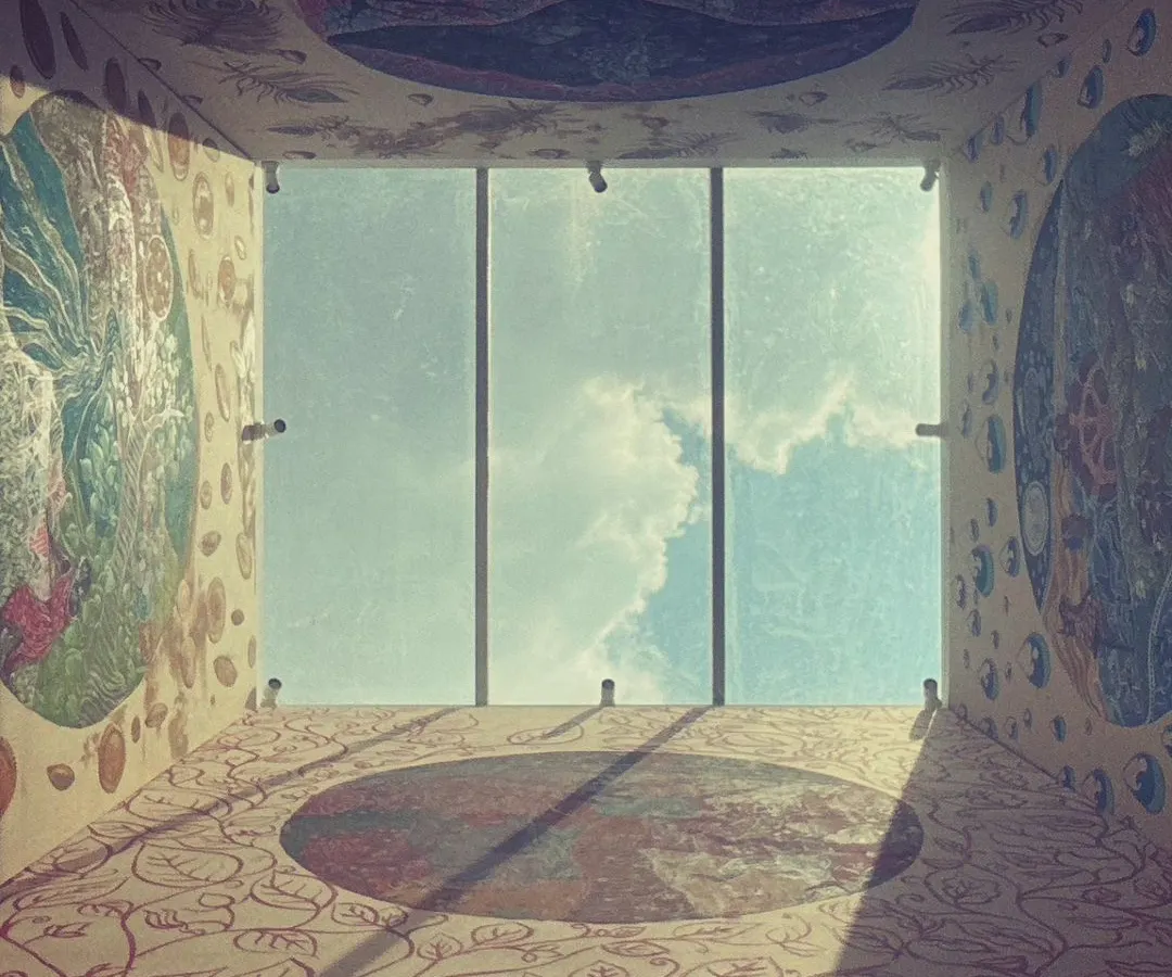 An immersive view of "The Thinai Project," a four-wall installation in a private residence. Each wall is a massive painting on silk, inspired by ancient Tamil landscapes and reinterpreted through a feminist lens. This photo, looking up towards the skylight, shows how the art interacts with natural light to create a living, breathing environment.