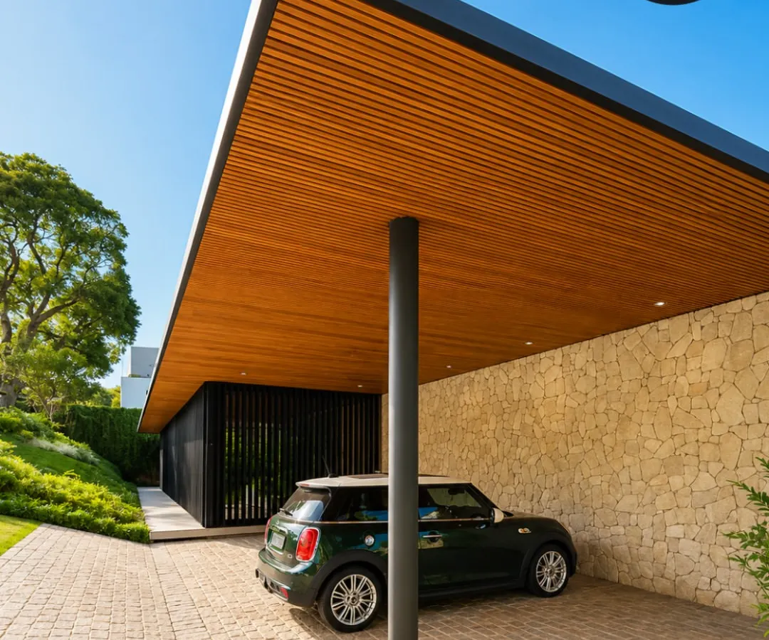 We designed this modern carport to feel both open and protective. The cantilevered roof with its rich wood-panelled ceiling is supported by a single, sleek pillar, creating an unobstructed, minimalist look that perfectly complements the home's architecture while providing excellent vehicle protection.