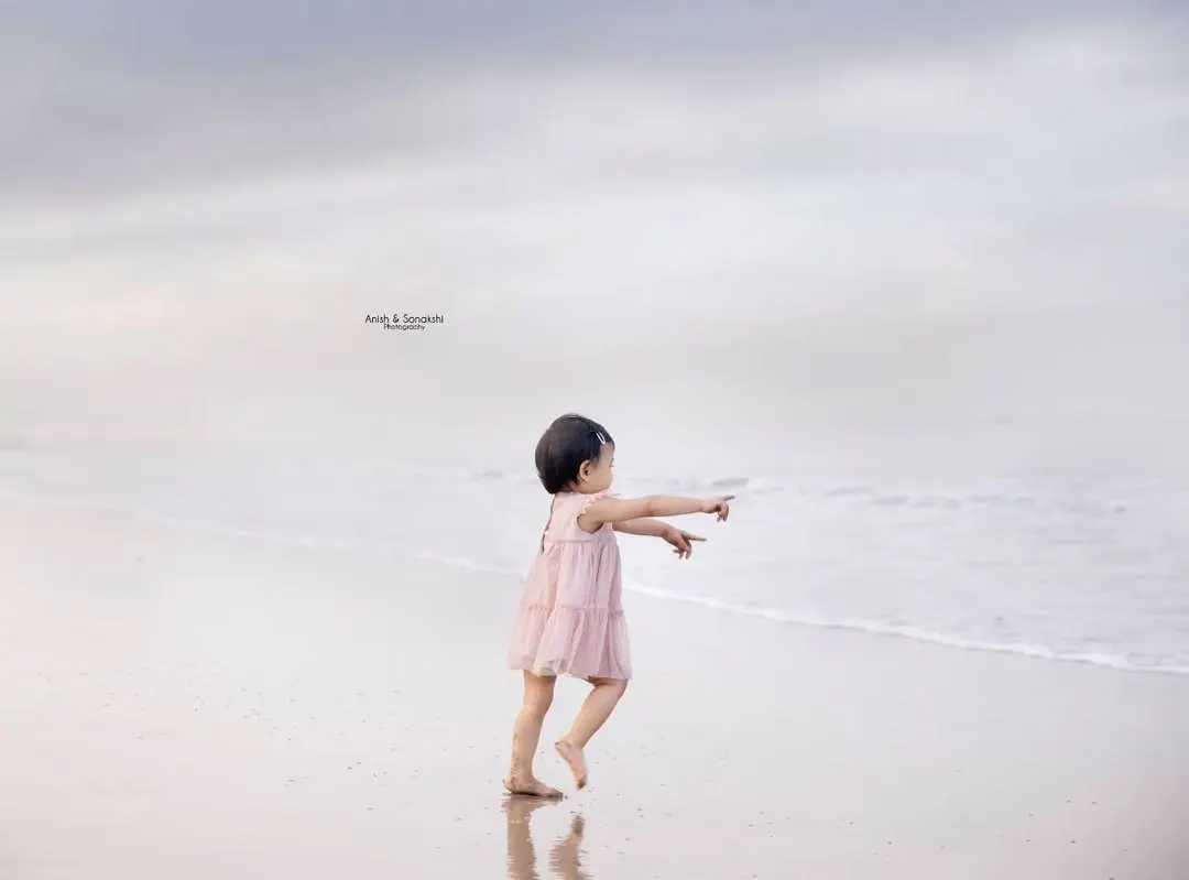 There's something magical about a child's first encounter with the ocean. We captured this beautiful, candid moment of a toddler chasing the waves on a quiet Mumbai beach. These are the dreamy, fleeting memories we feel so privileged to freeze in time.