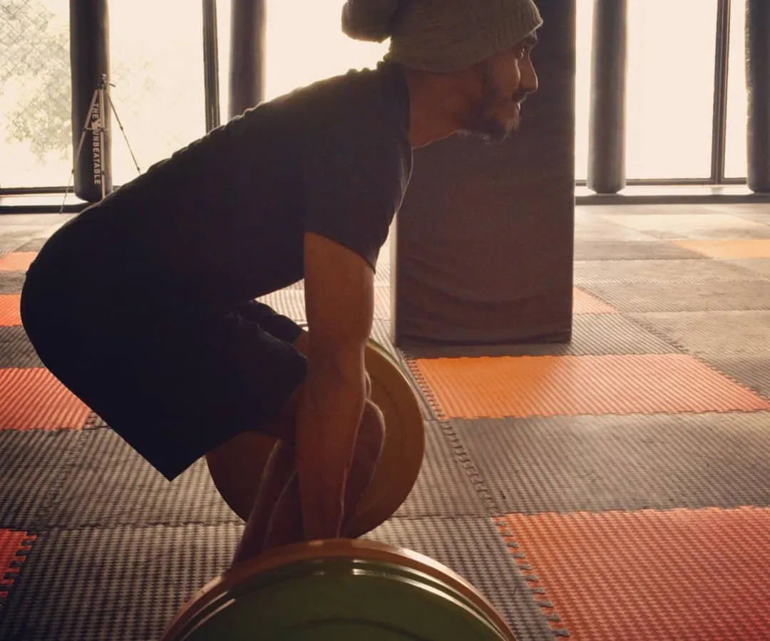 I always say, if you think lifting is dangerous, try being weak. Here I am setting up for a deadlift, a core exercise for building total body strength. Proper form is everything, and it's the foundation of all my strength training programs.