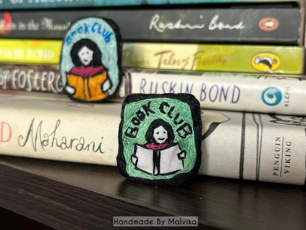 As a book lover myself, I had to create something for my fellow readers. I've placed these 'Book Club' badges right where they belong, among some of my favorite stories. It’s the perfect embroidered pin to add a literary touch to your jacket or tote bag.
