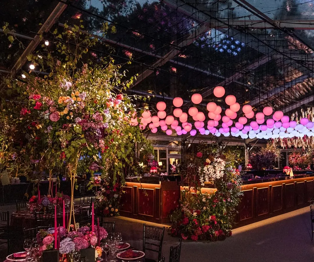 A moody, dramatic Sangeet inspired by the romance of Bridgerton. This setup in the British countryside features a clear-span marquee, lavish floral arrangements, and custom lighting to create a truly immersive, high-energy atmosphere.