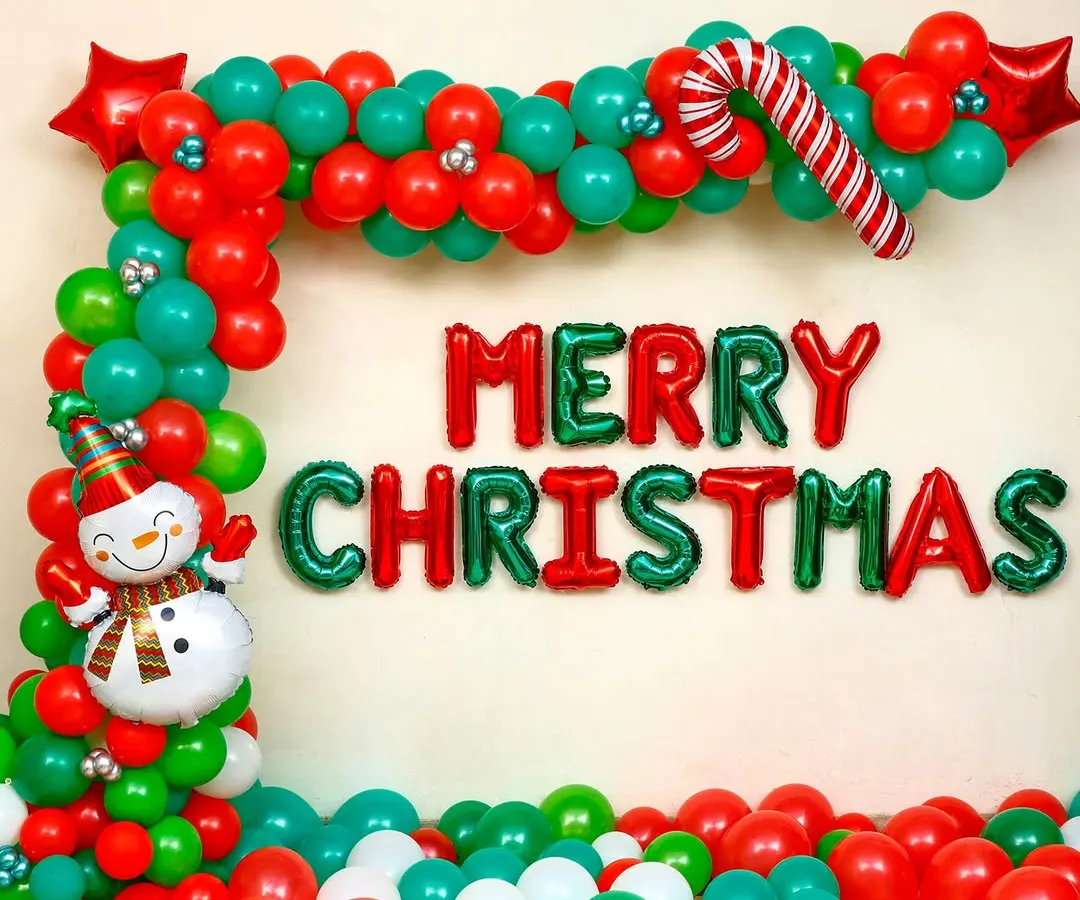 This is a classic Christmas decoration I set up for a client's home. It features a vibrant balloon garland arch in red and green, "Merry Christmas" foil letters, and charming details like a candy cane and a snowman foil balloon.