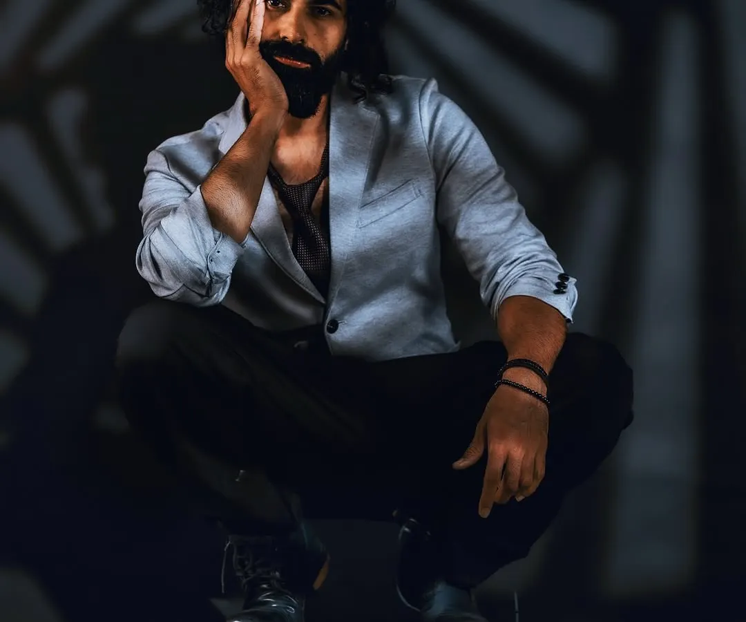 A portrait is a conversation between light and shadow. Here, I used gobo lighting to create a spiral pattern, framing the subject's intense and quiet presence. It’s a study in masculine portraiture, focusing on introspection over overt expression.