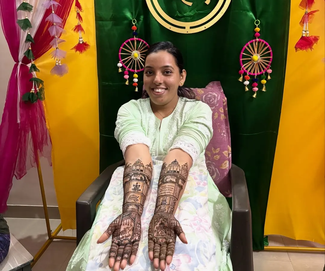 Seeing a happy bride is the best part of my job. Here is a full view of a custom bridal mehendi, extending from the palms to the elbows, with a smiling bride at her mehendi ceremony in Mumbai.