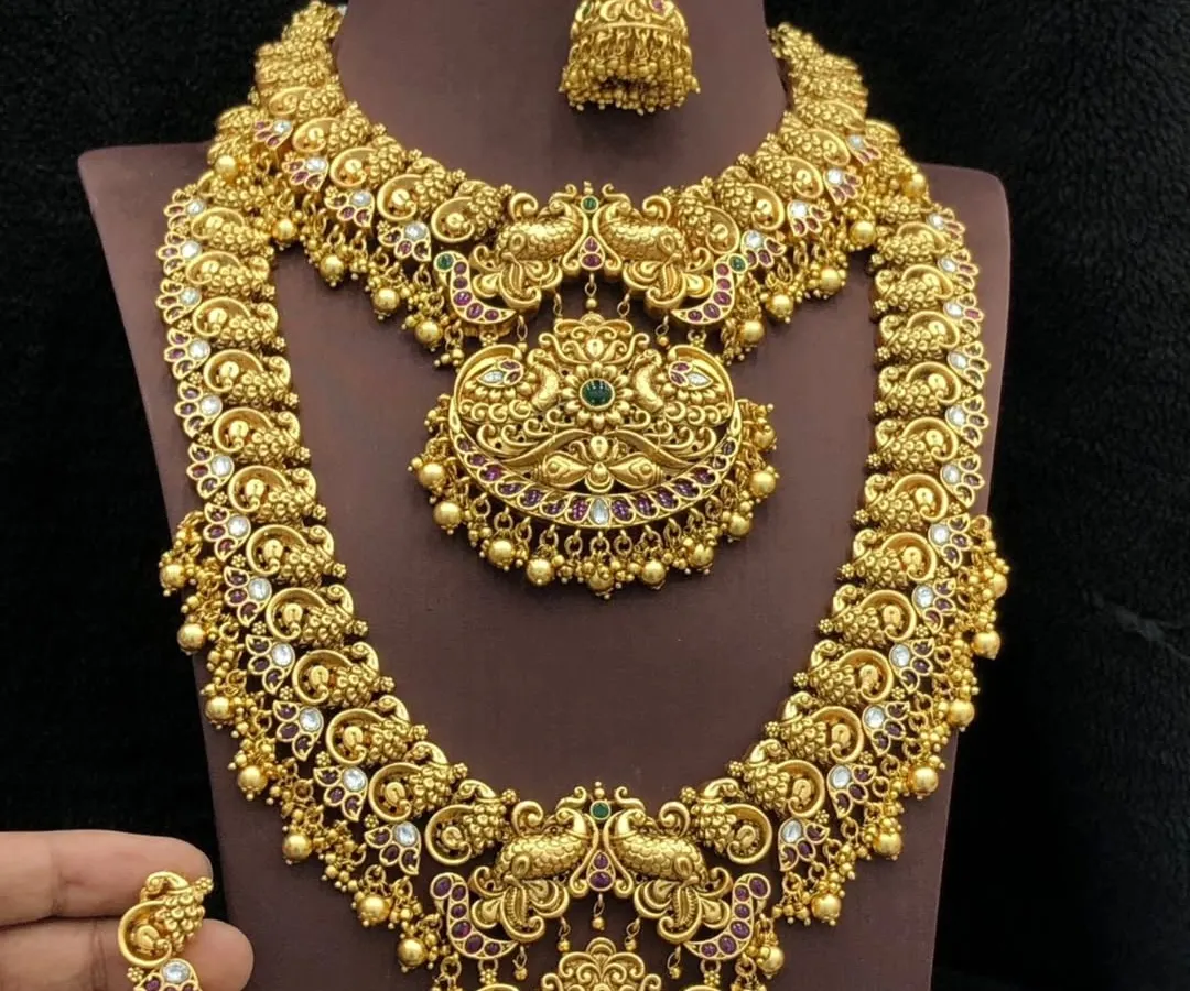 I am in awe of the grandeur of traditional South Indian temple jewellery. This complete rental set, featuring a short necklace, a long haar, and matching jhumkas, is handcrafted with intricate peacock motifs for an authentic and royal look.