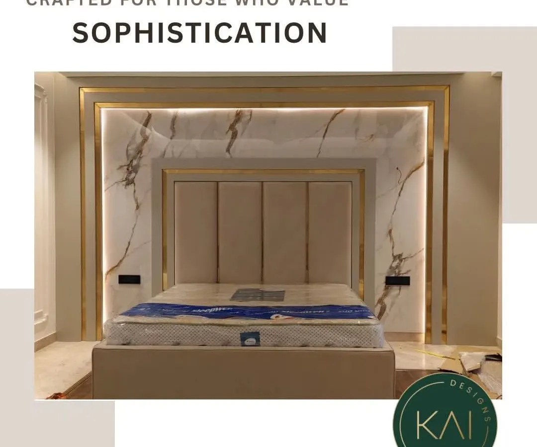 Elevate your bedroom into a luxurious retreat with our integrated design approach. This bespoke bed features a tall, panelled headboard set against a stunning marble wall with backlit gold accents, creating a dramatic and opulent focal point.